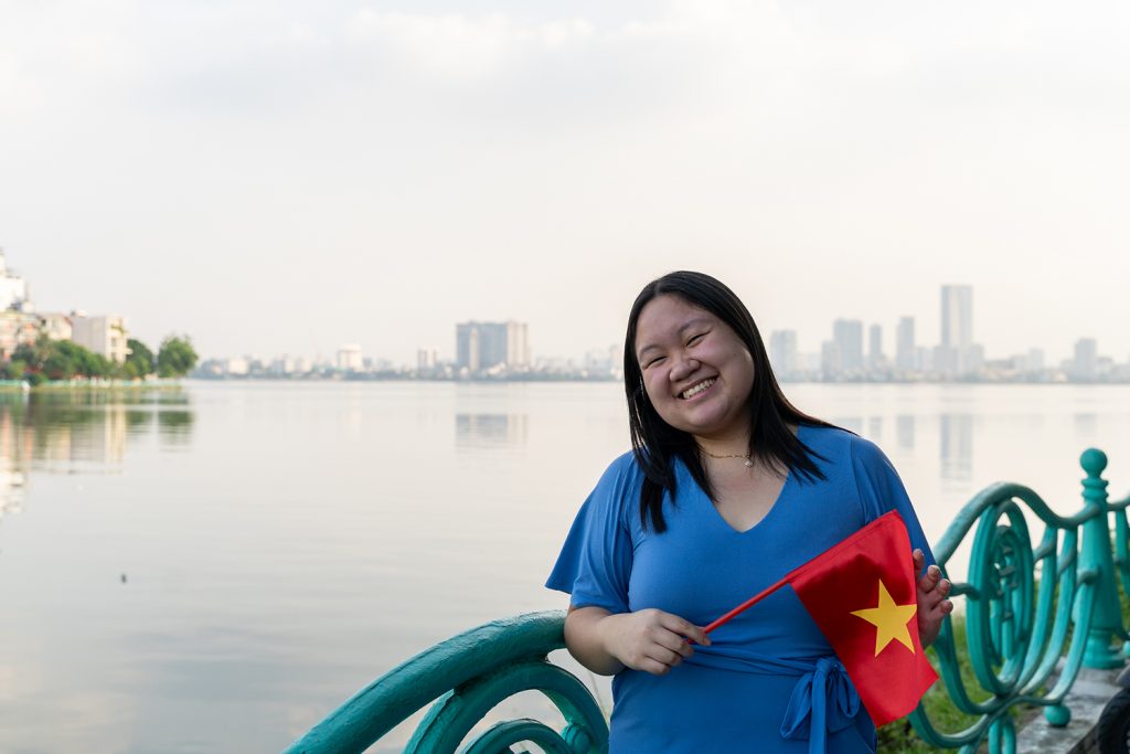 Lynna Vo '24 (ED), '25 (MA) poses with a Vietnamese flag at the beginning of her Fulbright grant. She spent an academic year as an English teaching assistant in Vietnam.