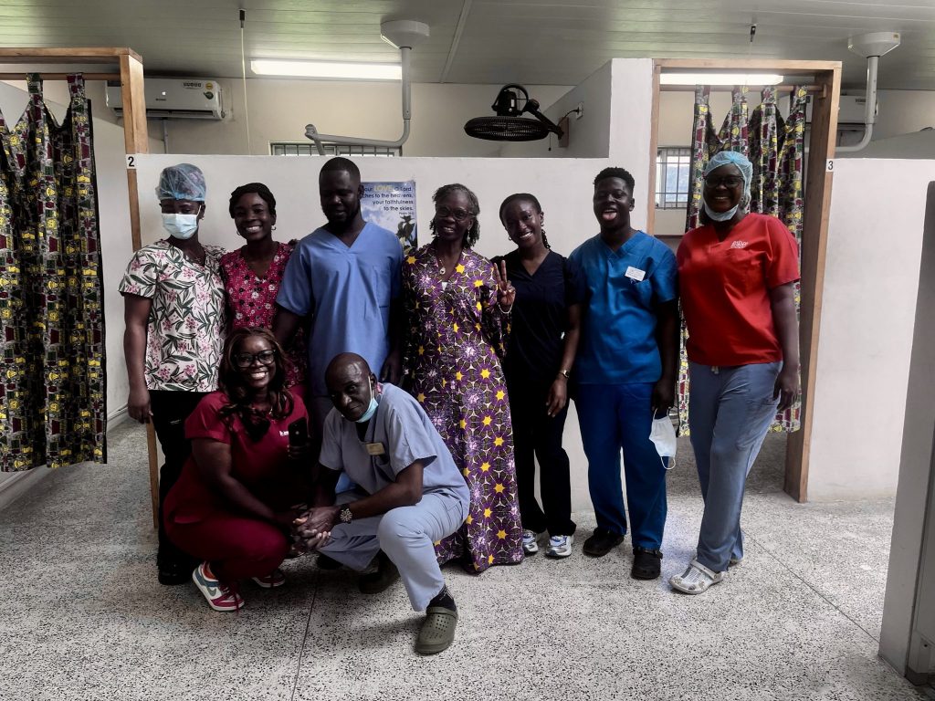 Second-year dental students Faith Joy Kollie and Asonyu Nshanji with a group of staff at the Trinity Dental Clinic in Liberia